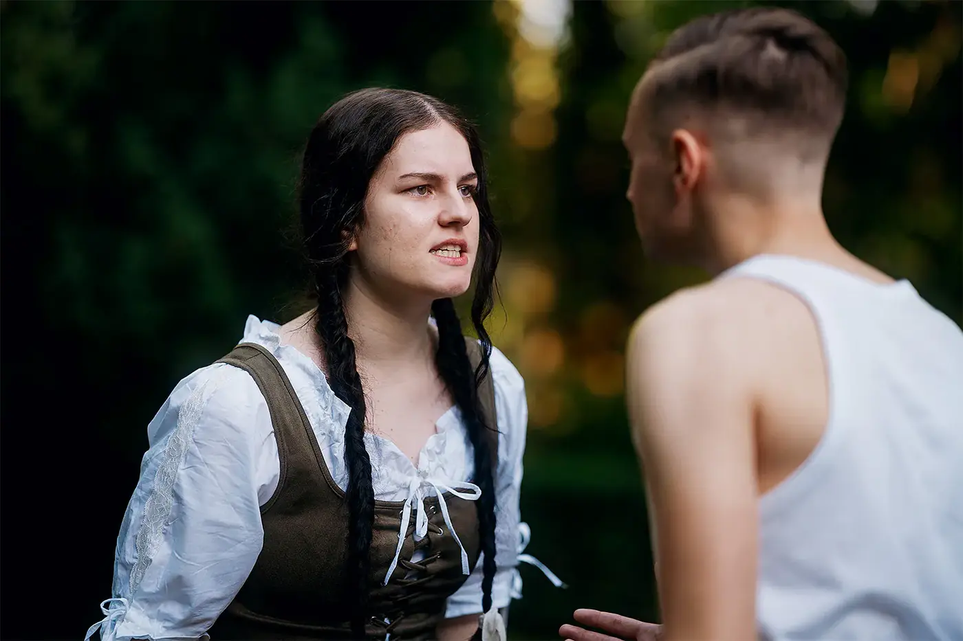 Junge Frau in ländlichem Kostüm streitet mit einem jungen Mann im Freien, Standbild aus dem IAF Abschlussfilm Kartoffelmädchen 2025