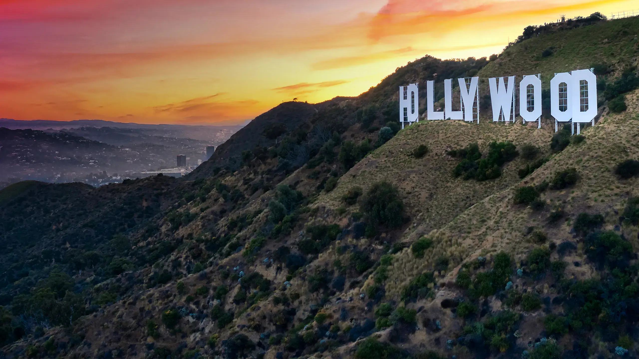 Hollywood-Schriftzug auf den Hügeln vor Los Angeles bei dramatischem Sonnenuntergang mit orangenem Himmel