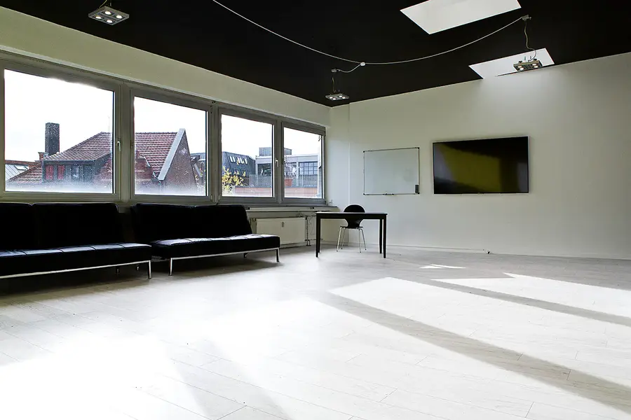 Heller Unterrichtsraum mit Whiteboard, Bildschirm und Dachblick über Köln