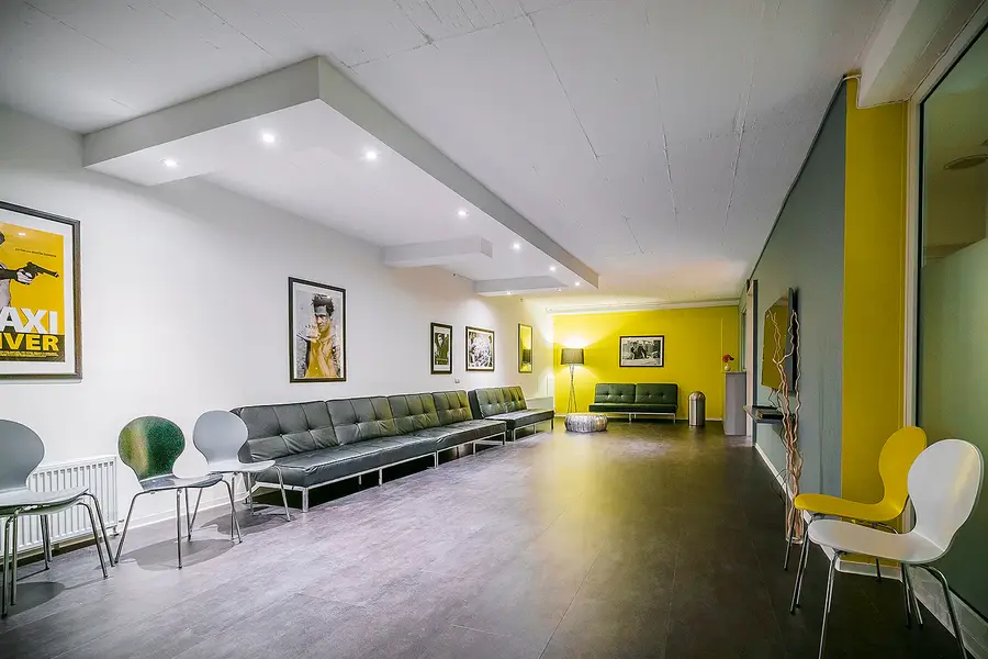 Foyer der Akademie mit Ledersofas und Filmplakaten an der Wand
