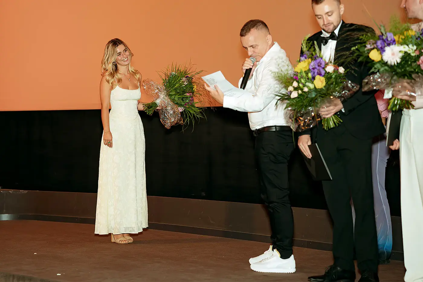Moderator verliest die Laudatio neben einer Absolventin auf der Bühne, IAF Abschlussfeier 2024 in Köln