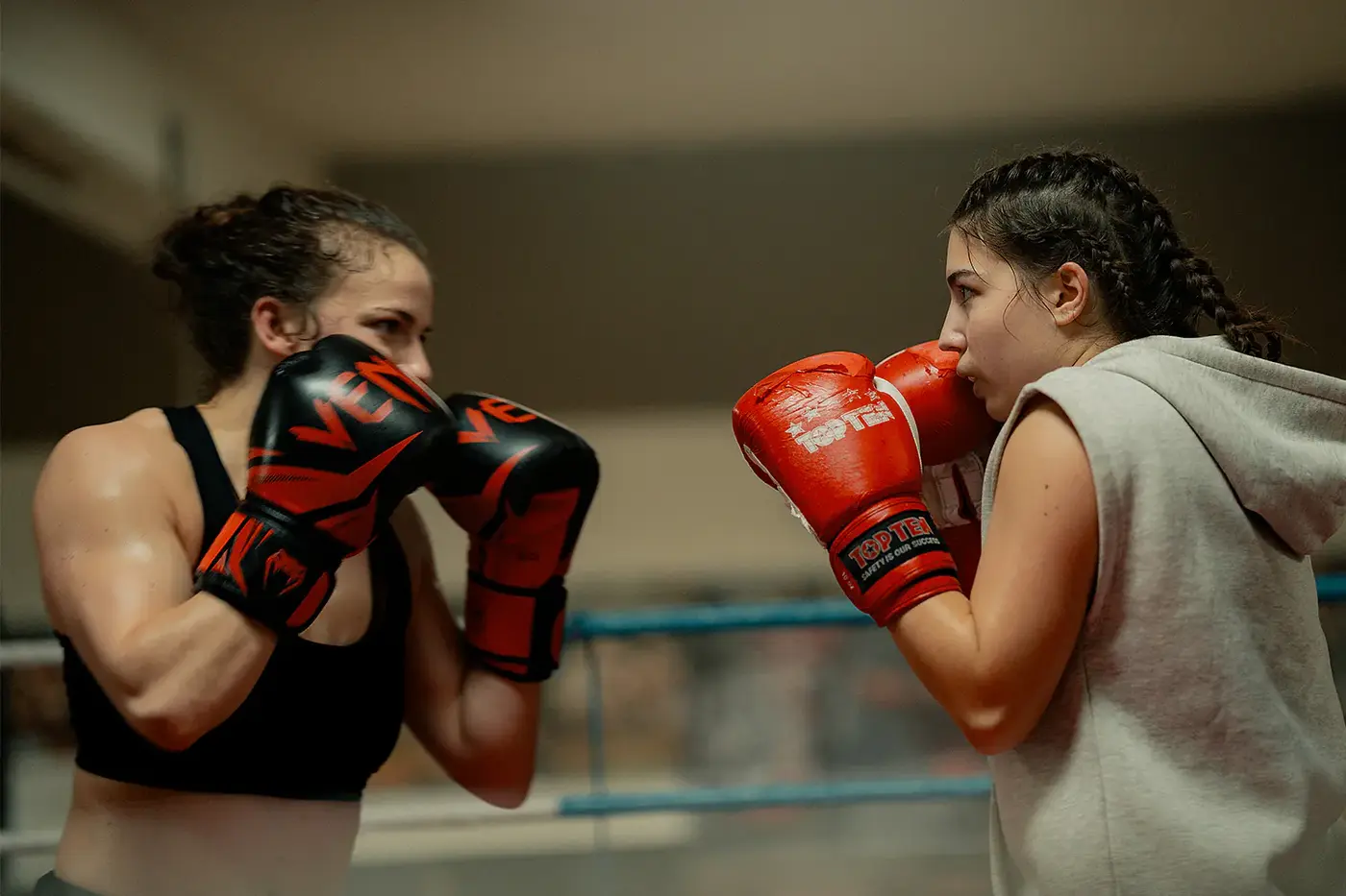 Zwei Boxerinnen in Kampfhaltung mit roten Handschuhen im Ring, Standbild aus dem IAF Abschlussfilm Boxschwester Tod 2025