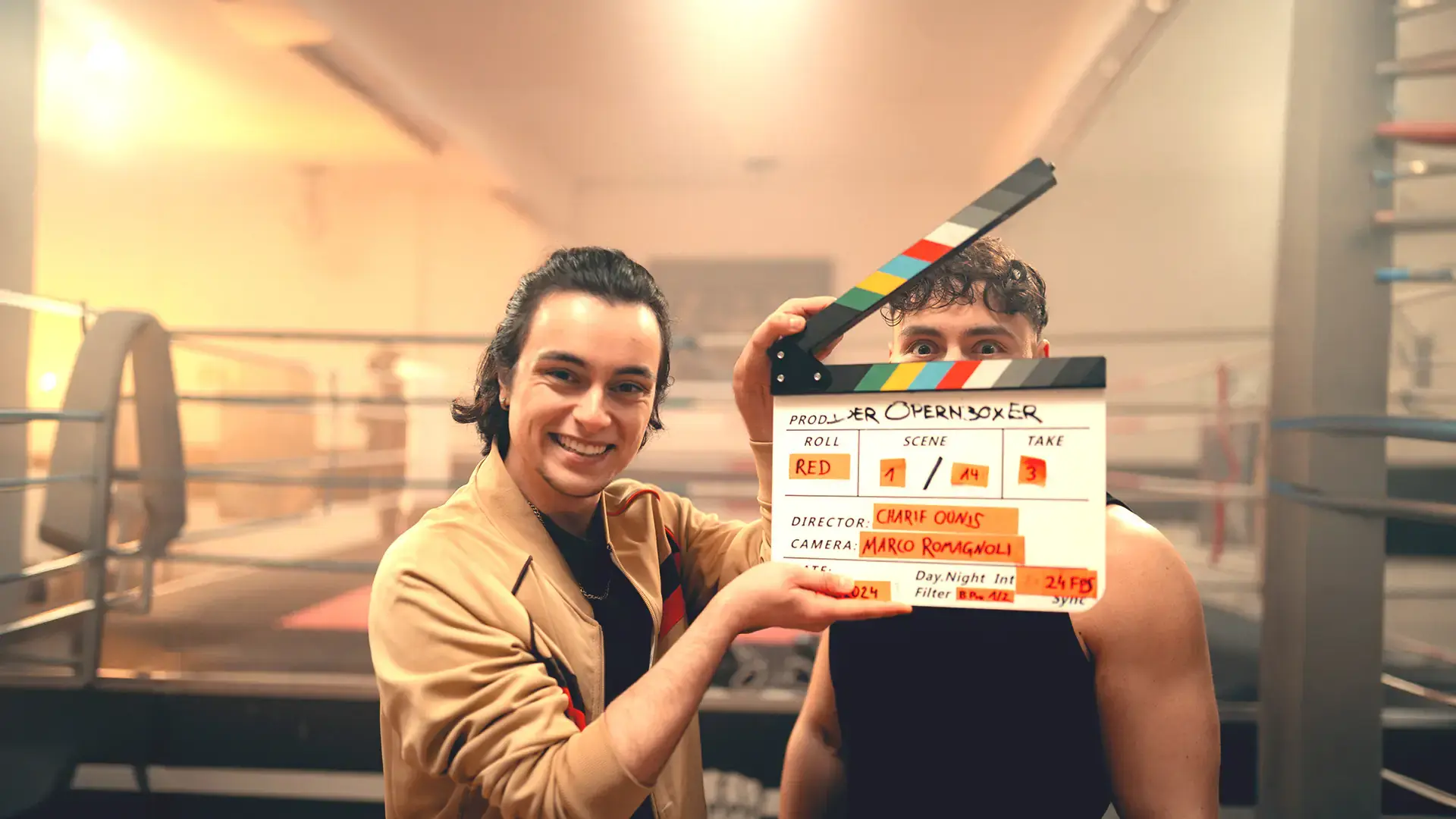 Schauspieler mit Filmklappe zum Abschlussfilm Opernboxer am Boxring